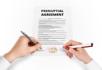 Man and woman sign prenuptial agreement near gold rings. Legal prenup document contract signing by newlywed couple. Marry partners signature on prenupt statement. Wedding ceremony conflict text.